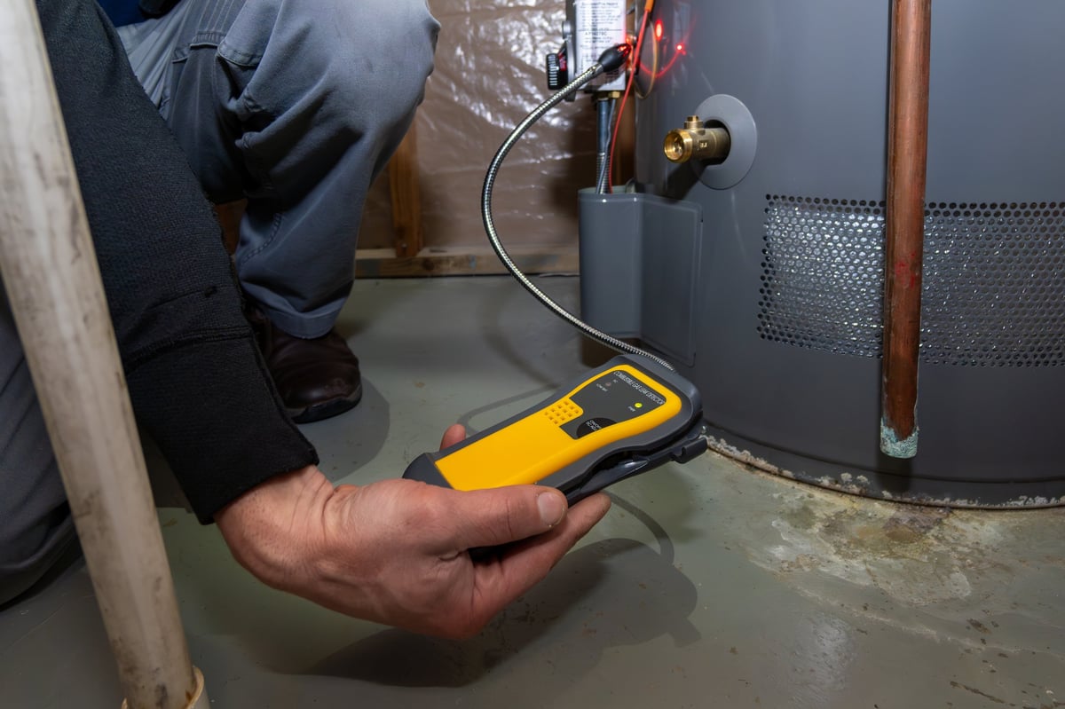 Home inspector using a carbon monoxide detector to test a gas furnace